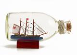 Decorative ship in glass bottle on wooden support