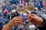 Hands holding glasses of champagne against new year tree