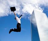 happy businessman jumping in front of a building