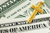 A golden cross on the dollar bills concept of In God We Trust