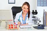 Smiling female medical doctor working with documents at office
