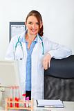 Portrait of female medical doctor standing at office desk
