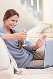 Portrait of a woman having a glass of white wine during a video conference