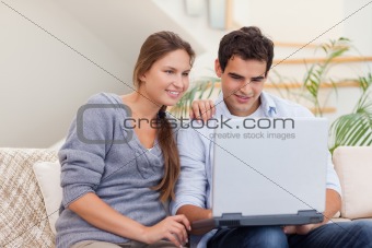 Smiling couple using a laptop