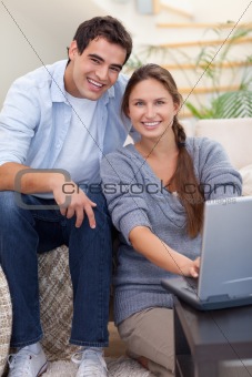 Portrait of a radiant couple using a notebook