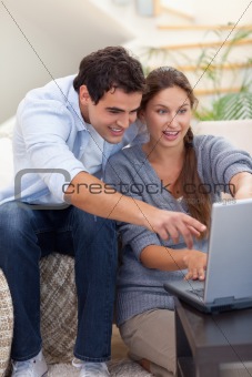 Portrait of a surprised couple using a notebook