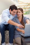 Portrait of a surprised couple using a laptop