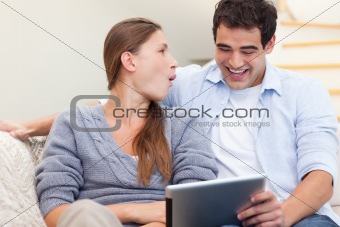 Laughing couple using a tablet computer