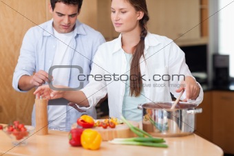 Cute couple using a tablet computer to cook