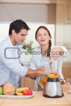 Portrait of a couple making fresh fruits juice
