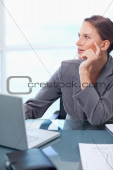 Portrait of a doubtful businesswoman working with a laptop
