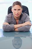 Portrait of a serious businesswoman leaning on her desk