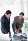 Businesswoman showing partner where to sign