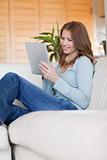 Smiling woman on the sofa with her tablet