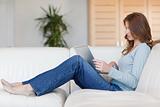 Woman sitting on the couch while working on her laptop