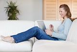 Laughing woman with her laptop on the sofa