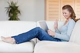 Laughing woman with her notebook on the sofa