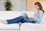 Woman booking flight online on her sofa
