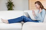 Happy smiling woman on the sofa with her laptop