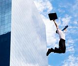 happy businessman jumping in front of a building