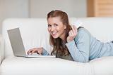 Smiling woman on the sofa using her credit card online