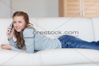 Young female phoning on the sofa