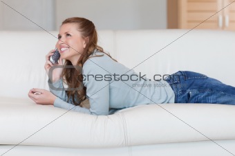 Young woman on the sofa having a nice conversation on the phone