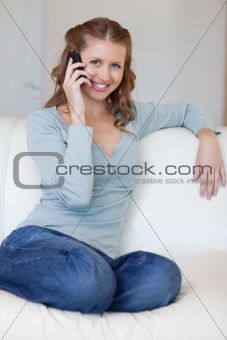 Woman sitting on the couch answering the phone
