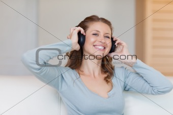 Young woman with headphones on the sofa