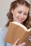 Close up of smiling woman reading a book