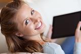 Shadowing smiling woman on the sofa with tablet