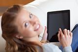 Above view of smiling woman using tablet on the sofa