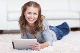 Smiling woman using her tablet on the floor