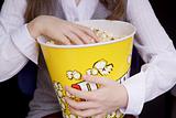 hand in a bucket of popcorn