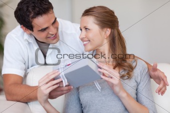 Woman smiling happily about the present she just got from her boyfriend