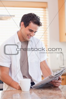 Man reading newspaper in the kitchen