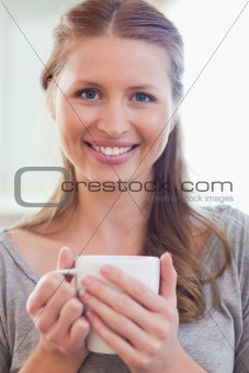 Close up of smiling woman with a cup of coffee