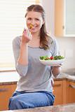Woman eating some salad in the kitchen