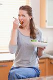 Woman eating salad in the kitchen