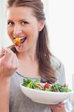 Close up of smiling woman eating salad