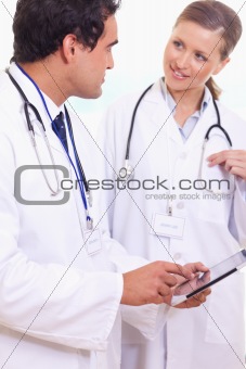 Assistant doctors talking about what's on the tablet