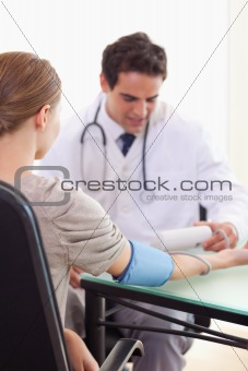 Doctor checking his patients blood pressure