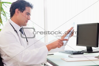 Side view of doctor with an x-ray at his desk