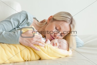 Mother relaxing next to her sleeping baby