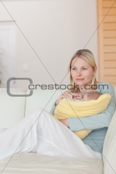 Mother sitting on the couch while holding her baby