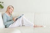 Side view of woman looking at catalog on the couch