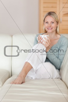 Woman relaxing on the couch with a cup of coffee