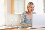 Smiling woman typing on her laptop