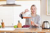 Woman pouring smoothie into a glass
