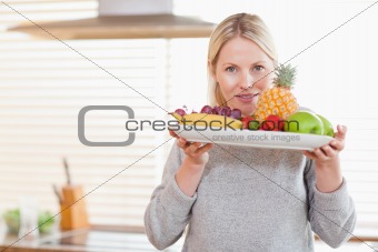 Woman holding a plate of fruits